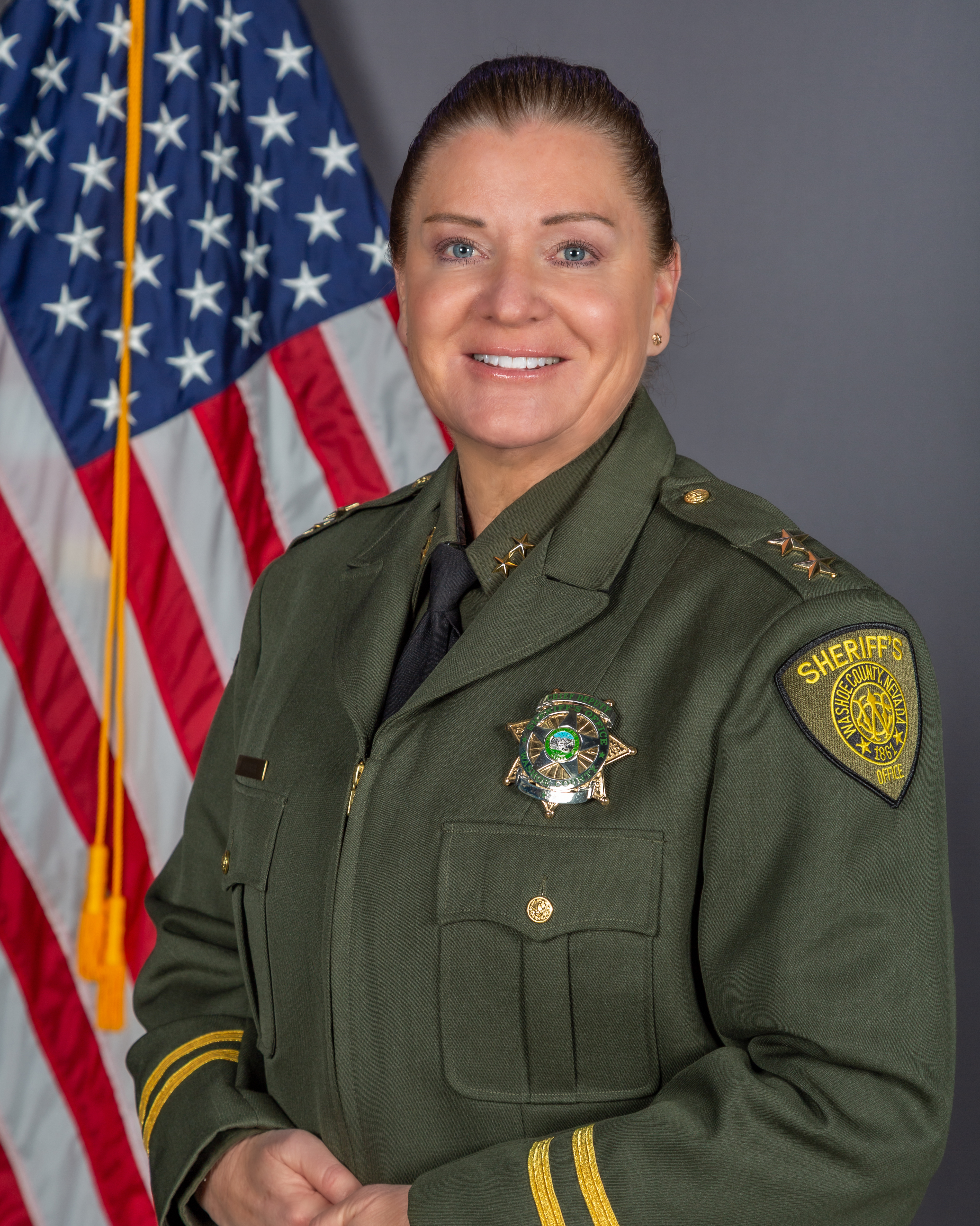 Assistant Sheriff Sandra Barboza, in WCSO uniform, poses in front of the American Flag