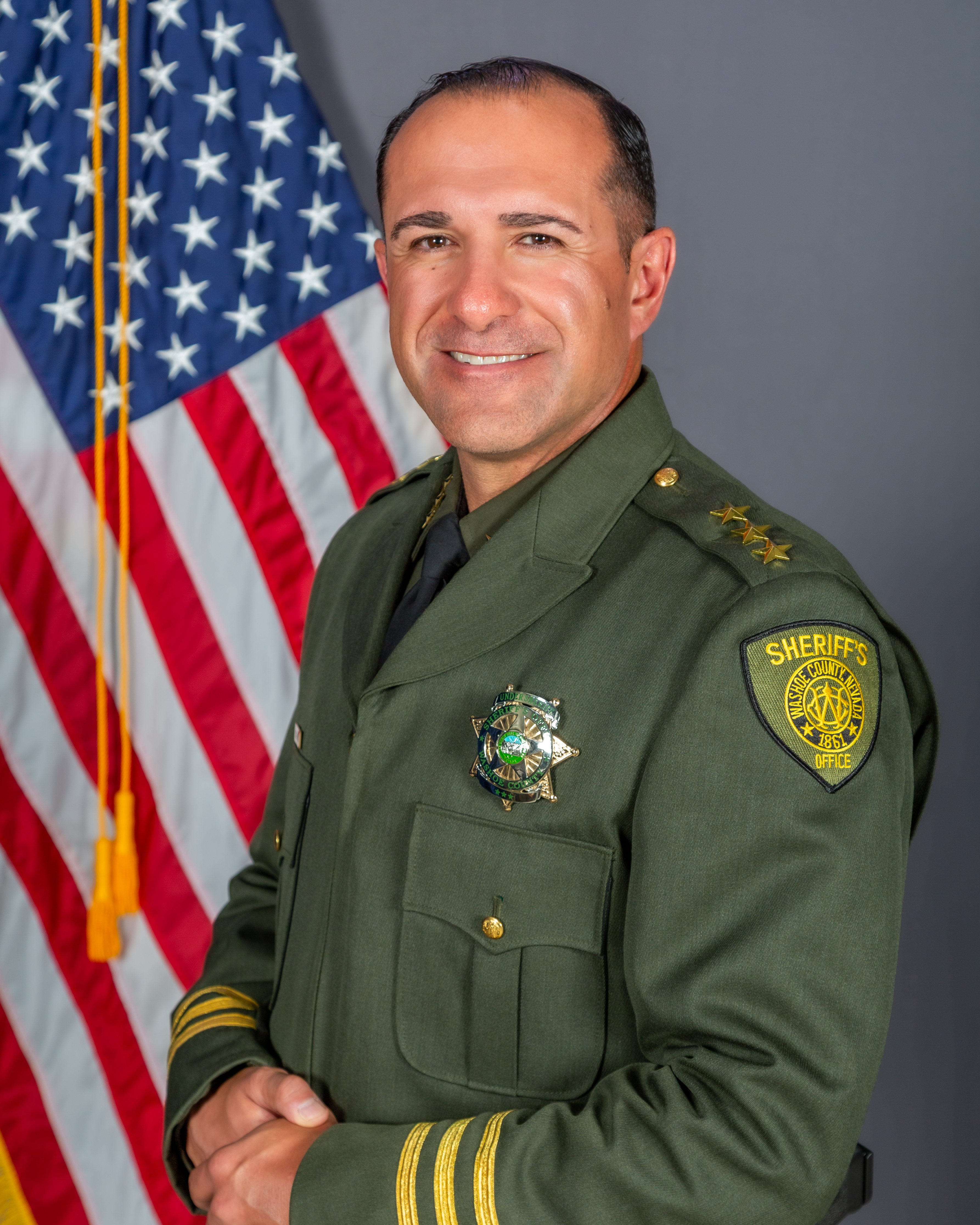 Undersheriff Corey Solferino, in WCSO uniform, poses in front of the American Flag
