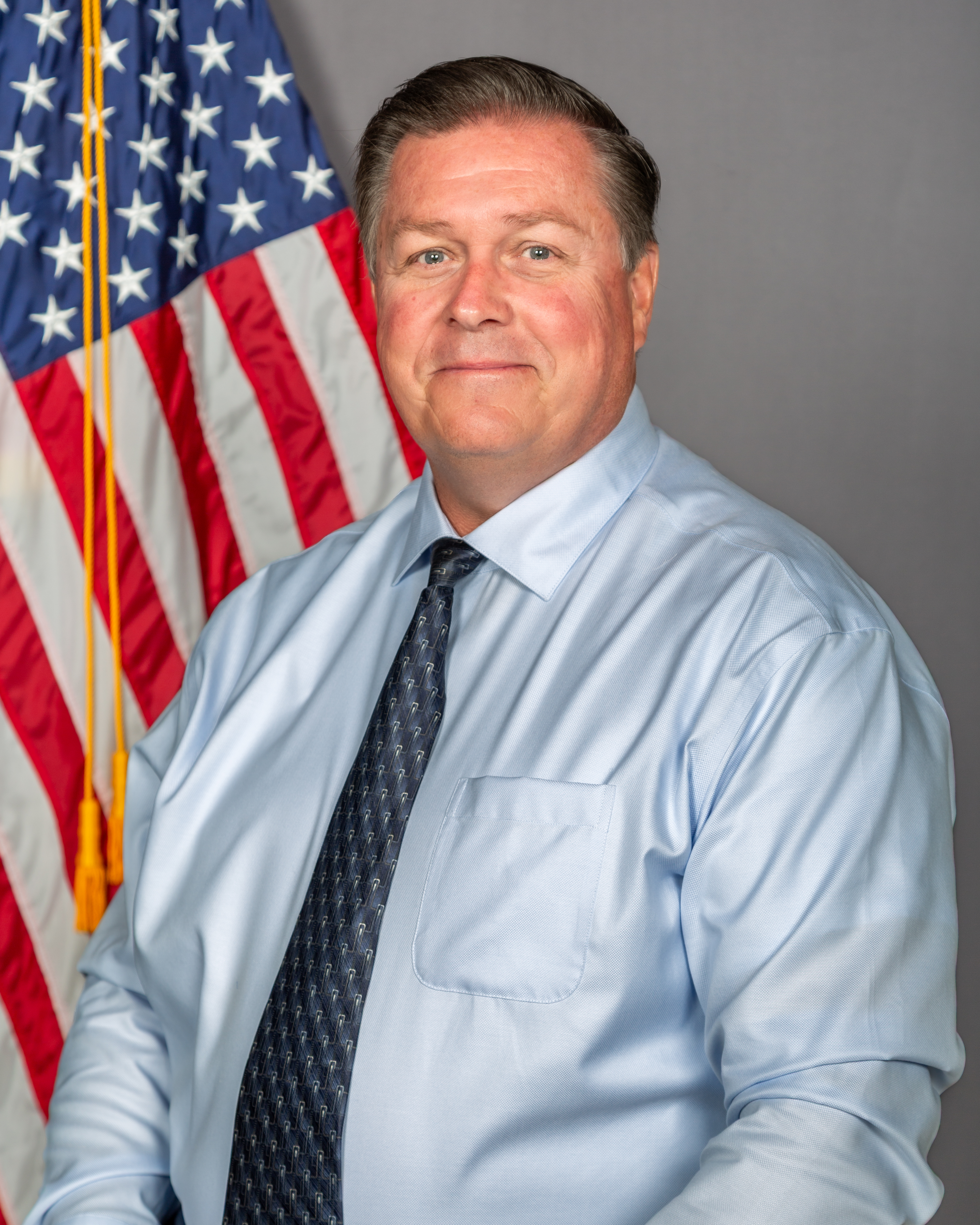 Acting Undersheriff Wayne Yarbrough, in WCSO uniform, poses in front of the American Flag